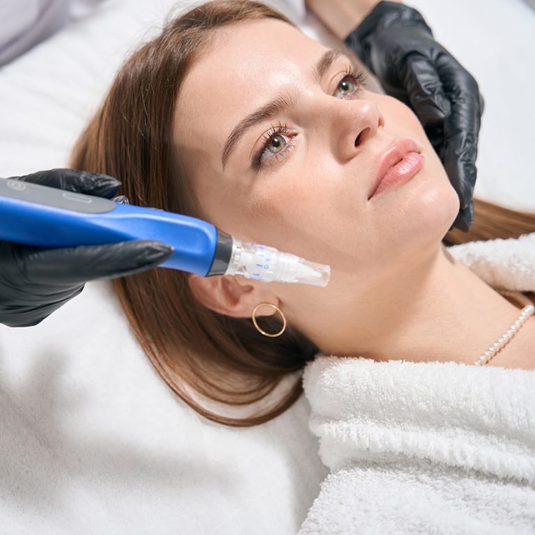 Partial female cosmetologist doing ultrasonic cleaning of face skin with skinpen with micro needle of young serious caucasian woman in blurred beauty salon. Concept of face skin care and rejuvenation